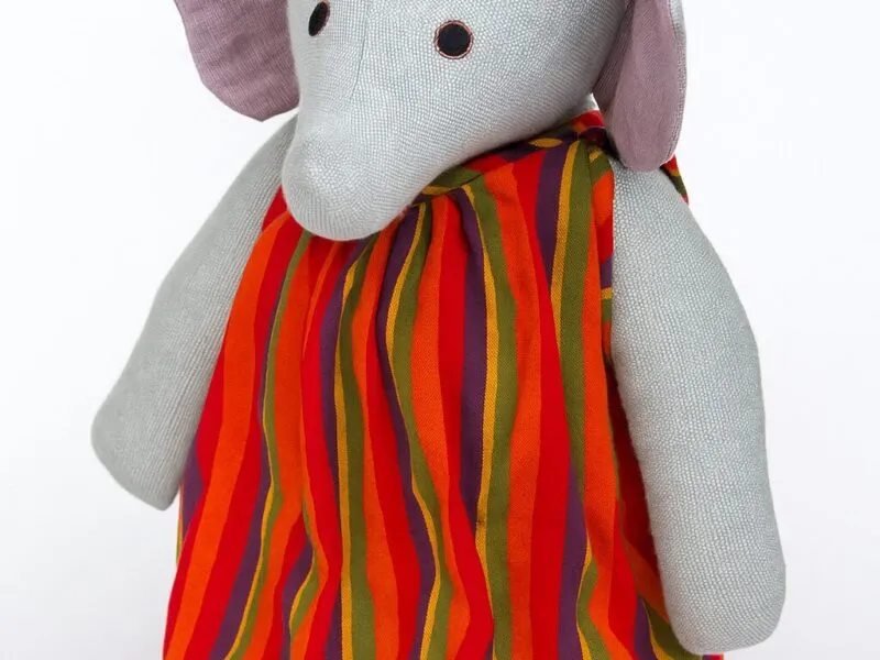 Barefoot large elephant in red striped dress 1